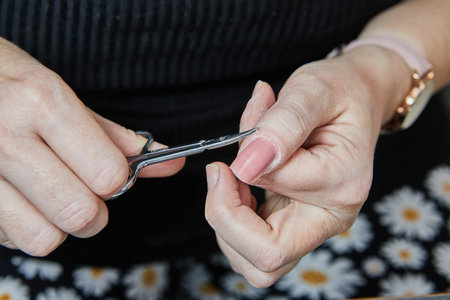 Skilled manicurist masterfully applies gel nail extensions and meticulously polishes nails using...