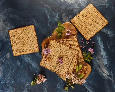 Passover is the Jewish Passover. A stack of matzo bread displayed on a wooden cutting board with a...