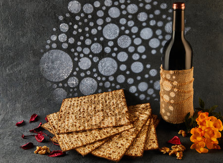 Passover is the Jewish Passover. A bottle of wine is placed beside a pile of matzah and a bouquet of flowers, creating a beautiful display of food ingredients and natural elementsの写真素材