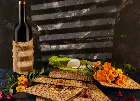 Passover is the Jewish Passover. A bottle of wine is placed beside a pile of matzah and a bouquet of flowers, creating a beautiful display of food ingredients and natural elementsの写真素材