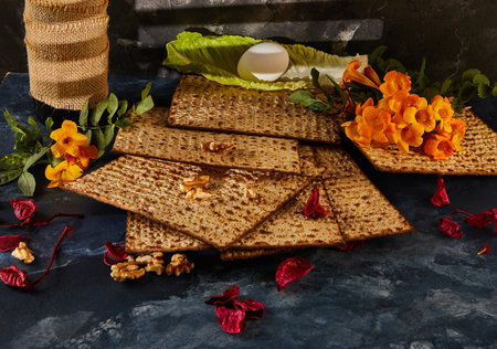 Passover is the Jewish Passover. A bottle of wine is placed beside a pile of matzah and a bouquet of flowers, creating a beautiful display of food ingredients and natural elementsの写真素材