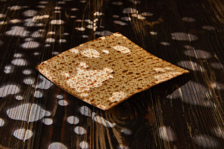 Passover celebration concept - Jewish holiday Passover. Stack of matzo on a wooden background with a beautiful composition with a whimsical light on the matzo.の写真素材