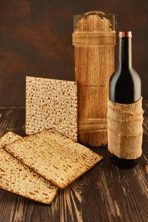 Passover celebration concept - Jewish holiday Passover. Stack of matzo and bottle of wine on a wooden background with a beautiful composition with a wooden box.の写真素材