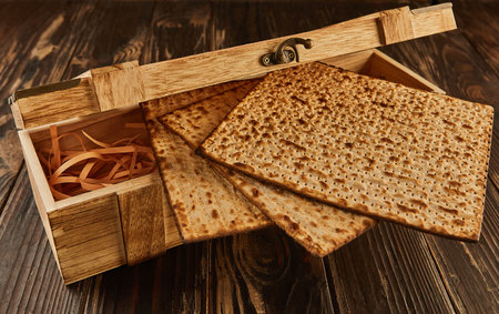 Passover celebration concept - Jewish holiday Passover. Stack of matzo on a wooden background with a beautiful composition in a wooden box.の写真素材