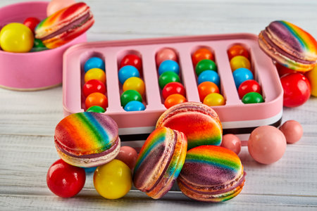 The table is filled with a variety of candies and gums, showcasing a variety of rainbow macaron flavors and textures to satisfy any sweet tooth.の写真素材