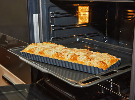 A freshly baked pie is being removed from the oven, filling the kitchen with a delightful aroma. This delicious dish is ready to be enjoyedの写真素材