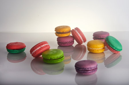 A cup of coffee sits on the table, accompanied by a variety of colorful macarons. The food and drinkware create a delightful display of ingredients in this cuisineの写真素材