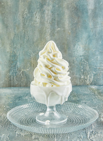 A liquid chocolate sauce delicately poured over a cup of whipped cream, creating an artistic resemblance to a feather painting on a canvasの写真素材