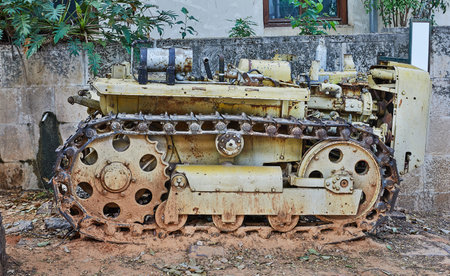 A very old tractor, on caterpillar tracks, from the beginning of the century.