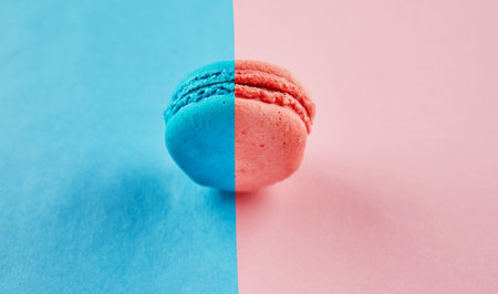 Multi-colored blue-pink macaron on a blue-pink background.