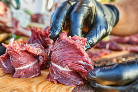 A variety of raw meat cuts, including ribs and tenderloin, displayed on a wooden board, ready for preparation and cooking.の写真素材