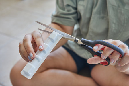 A close-up of a gray British Shorthair cat receiving a loving chin rub, showing a content and relaxed expression.の写真素材