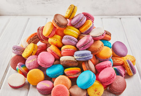 A delightful pile of assorted colorful macarons, highlighting their vibrant hues, delicate textures, and sweet flavors.の写真素材