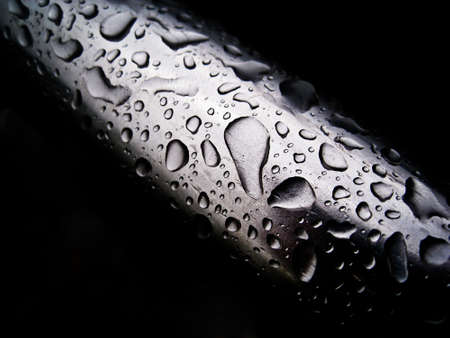 Water drops on a metal pipeの写真素材