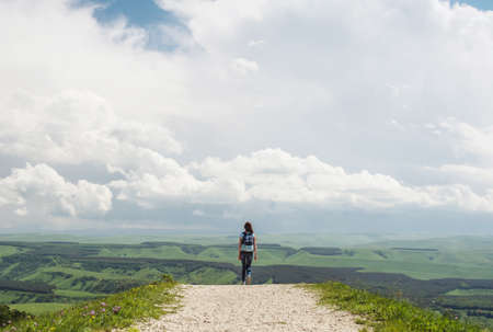 The girl goes to the horizon against the skyの写真素材