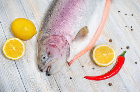 Big fresh trout on the table with lemon and spicesの写真素材