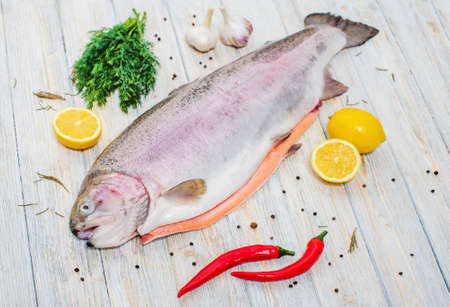 Big fresh trout on the table with lemon and spicesの写真素材