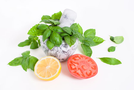 Fresh basil in a stone mortar for chopping and vegetables for saladの写真素材
