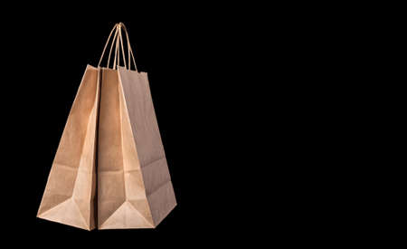 Two brown paper bags with cardboard handles on a black background. Copy spaceの写真素材