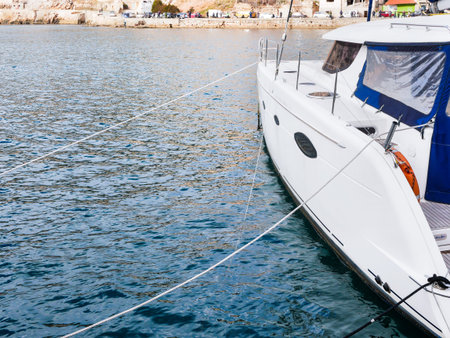 A beautiful catamaran yacht moored by ropes at the marina. Copy space. Close-up