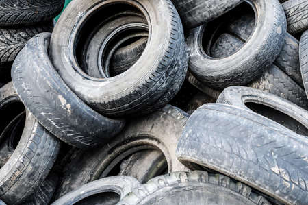 A lot of different old, dirty worn out car tires in a landfill. Close-upの写真素材