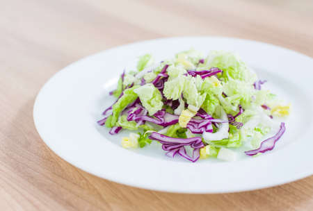 Fresh vegan red and green cabbage salad close-up on the tableの写真素材