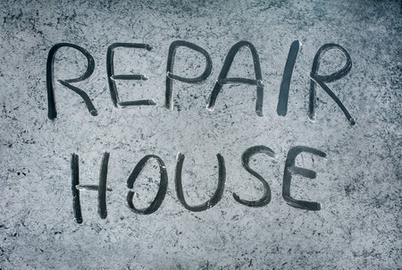 The inscription Home repair with a finger on dirty glassの写真素材