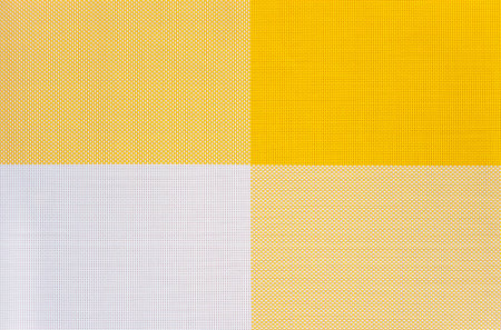 Yellow and white symmetrical background from perforated squares. Copy space. Billet