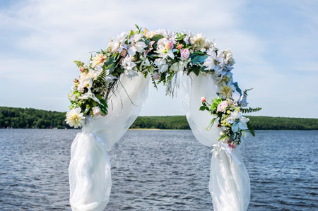 Beautiful wedding arch for registration with flowers on a background of water. Close-upの写真素材