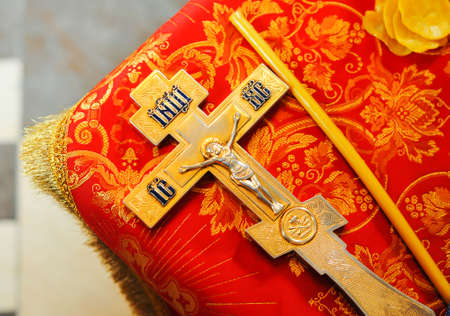 Gold metal Orthodox cross and candle on red cloth. Details in the Orthodox Christian Churchの写真素材