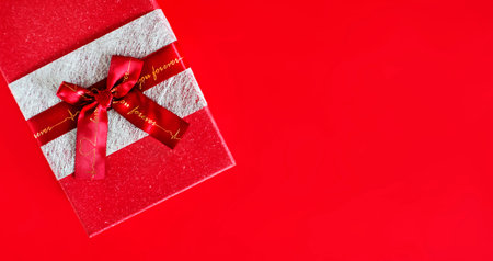 red gift box with a bow on a red background. copy spaceの写真素材