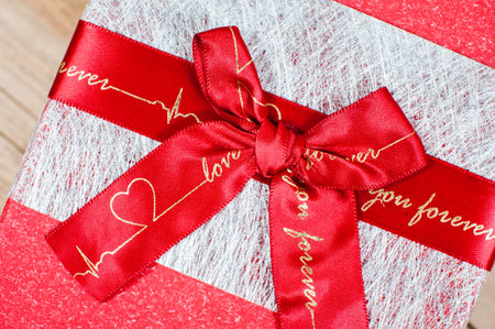 Red bow with heart and love on a gift box. Close-up