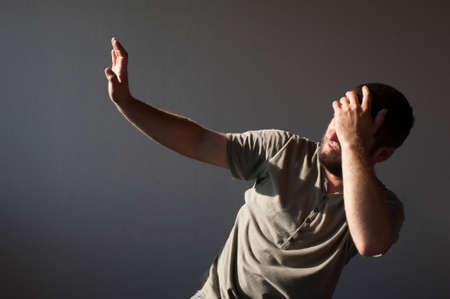 A drunk man in the morning lies on the bed with a bottle of alcohol in his hand. Hangover Syndrome. Alcoholism conceptの写真素材