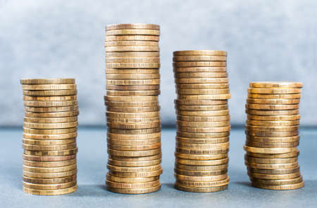 A man puts a coin into a pile. The concept of accumulating or saving money. Close-upの写真素材