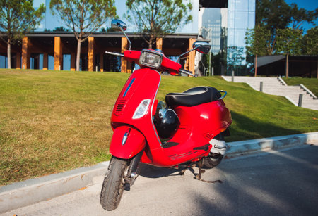 Beautiful red vintage moped on the street in summerの写真素材