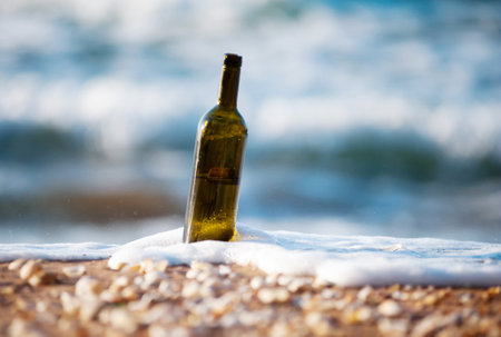 a bottle of wine on the beach against the background of the seaの写真素材