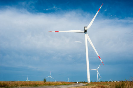 Many large wind generators in a field against the background of the sky and clouds