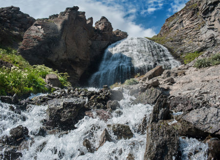 Beautiful large waterfall in the mountains close-up, view from below. Splashes of waterの写真素材