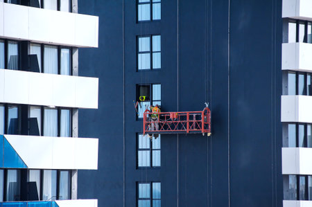 Window cleaners on the facade of a modern high-rise buildingの写真素材