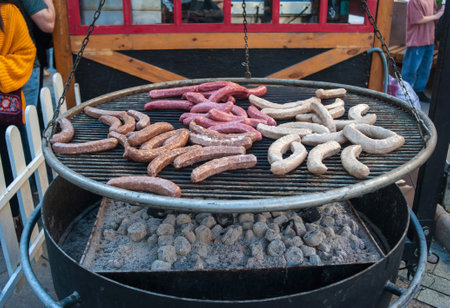 Street sausages are grilled on a large grill on a city streetの写真素材