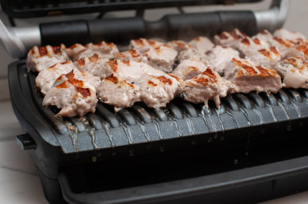 meat is fried on a modern electric grill in the kitchen close-upの写真素材