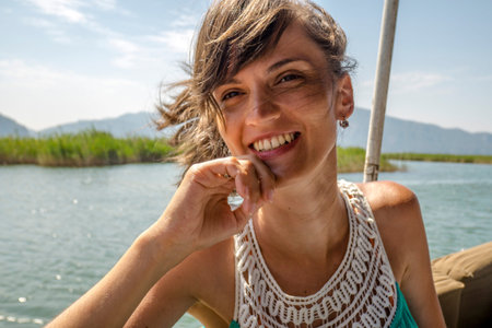 Mysterious young woman enjoying the tropical nature while riding in a boatの写真素材