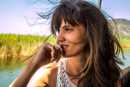 Mysterious young woman enjoying the tropical nature while riding in a boatの写真素材