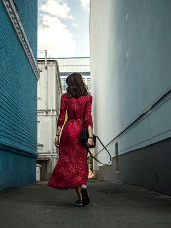 Sexy, happy girl, brunette, dancing in the city between blue buildings. Summer vacation, travel to Europe.の写真素材