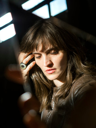 Reflection of the face of a mysterious girl in a shard of a mirrorの写真素材