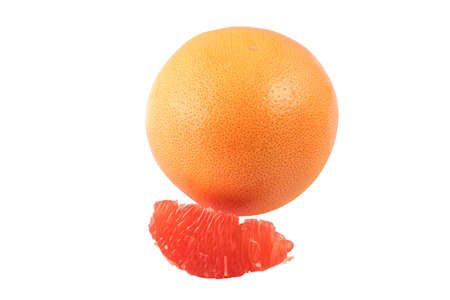 One whole grapefruit and also sliced pieces of grapefruit on a white backgroundの写真素材