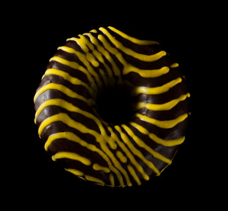 American donut covered with chocolate on black backgroundの写真素材