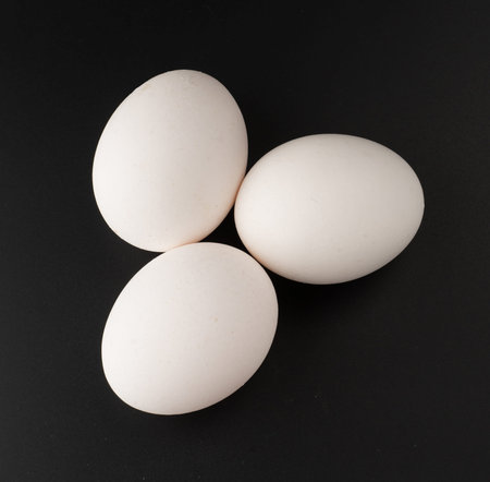 chicken egg raw in the shell on a black background in isolation