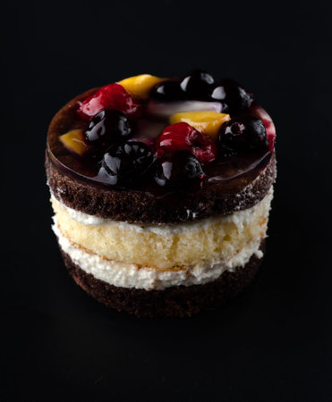 Pastry stuffed with berries and citrus fruits on a black background isolated, side view,...