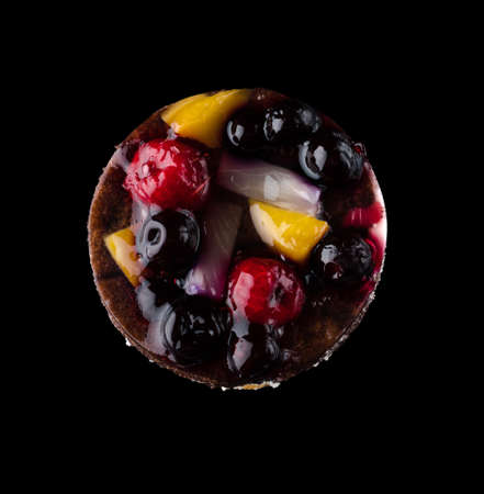 Pastry stuffed with fruits, berries and citrus fruits on a black background in isolation, view from the top, confectionery product.の写真素材